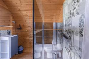 a bathroom with a toilet and a shower at Pink Pod in Saint-André