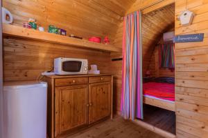 a small bedroom with a bed in a wooden cabin at Pink Pod in Saint-André