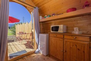 a kitchen with a microwave and a door to a porch at Pink Pod in Saint-André +6 photos