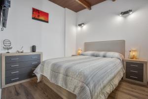 a white bedroom with a bed and a dresser at El Refugio De Los sueños in Uga
