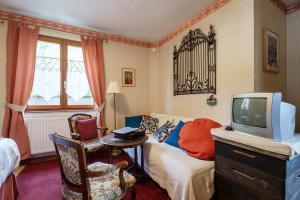 a living room with a bed and a tv at Bienvenue-Willkommen in Boersch