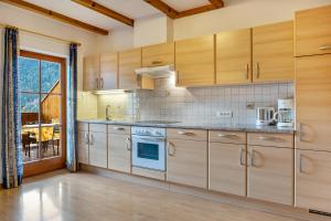 a kitchen with wooden cabinets and a stove at Oberpatiglhof - Anna in Brie +11 photos