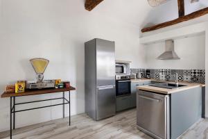 a kitchen with a stainless steel refrigerator and a counter at Gîte Du Parc in La Celle-Saint-Avant