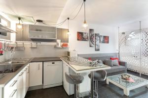 a kitchen with white cabinets and a table and a couch at Estudio Yumbo Playa Del Ingles in San Bartolomé