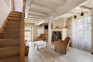 a living room with a staircase and a fireplace at Gîte Du Parc in La Celle-Saint-Avant