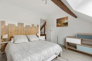 a white bedroom with a bed and a dresser at Gîte Du Parc in La Celle-Saint-Avant