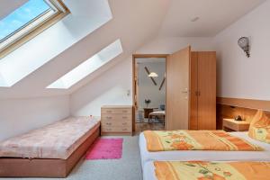 a attic bedroom with two beds and a window at Ferienwohnung Ufert in Meißen