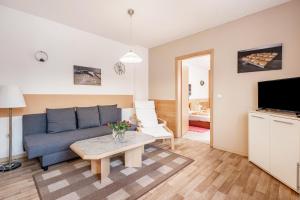 a living room with a blue couch and a table at Ferienwohnung Ufert in Meißen