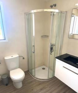 a bathroom with a toilet and a glass shower at Villa los Tres Menorca in Cala en Bosc +7 photos