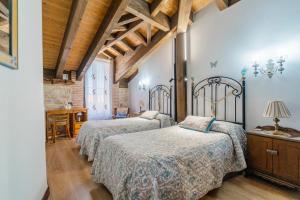 a bedroom with two beds and a table in a room at El Rincón de Hornuez in Moral