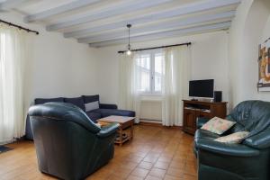 a living room with two leather chairs and a tv at Gite du maine in Langon