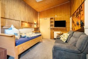 a room with a bed and a couch and a tv at Ferienwohnung mit Aufenthaltsraum in Ruhland