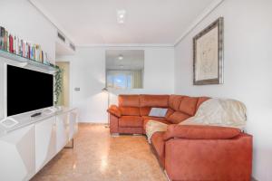 a living room with a couch and a television at Calpe Vistas y Playa in Calpe