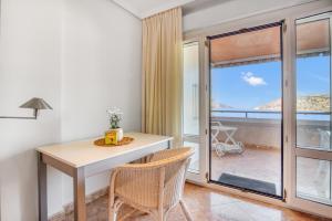 a room with a table and chairs and a balcony at Calpe Vistas y Playa in Calpe