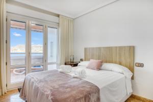 a bedroom with a large bed and a balcony at Calpe Vistas y Playa in Calpe +13 photos