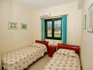 a bedroom with two beds and a window at Sami Beach Villas Nefeli in Karavomylos