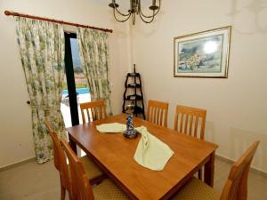 a dining room with a wooden table and chairs at Sami Beach Villas Nefeli in Karavomylos +19 photos