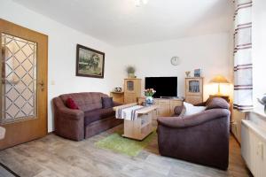 a living room with two couches and a television at Ferienwohnung Lüssow in Lüssow +19 photos