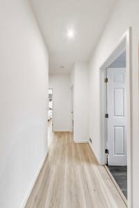 an empty hallway with white walls and wooden floors and an open door at 3BR recently renovated SOMA flat in San Francisco