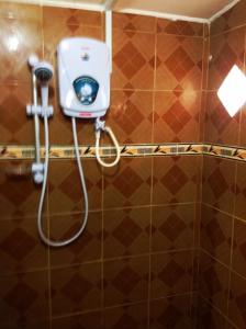 La salle de bains est pourvue d'une douche et d'un tuyau. dans l'établissement Nur Muslim Homestay At Kota Bharu, à Kota Bharu