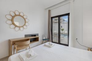 a bedroom with a bed and a mirror and a desk at Luxsuites in Chania +61 photos