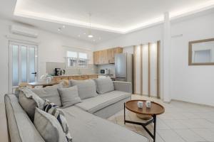 a white living room with a couch and a kitchen at Luxsuites in Chania