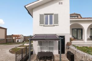 a white house with a patio with a table at Blueyes House Tuscany in Artimino