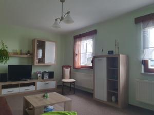 a living room with a tv and a table at Ferienwohnung Rochlitzer Berg Blick in Seelitz