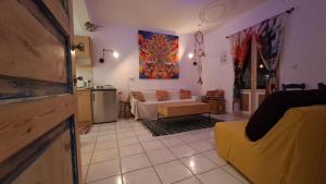 a living room with a yellow couch and a kitchen at Syros Mandala Studio in Ano Syros