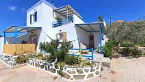 a white house with blue railing and a yard at Syros Mandala Studio in Ano Syros