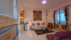 a living room with a table and a kitchen at Syros Mandala Studio in Ano Syros
