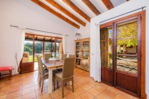 a dining room with a wooden table and chairs at Finca Na Palada in Artá