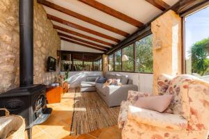 a living room with a stone wall and a fireplace at Finca Na Palada in Artá