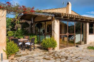 a patio with glass doors and a table and chairs at Finca Na Palada in Artá