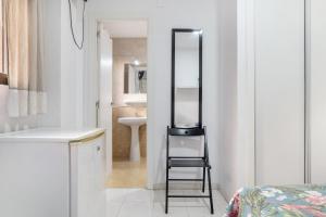 a small bathroom with a mirror and a stool in it at Hostal Avenida in Conil de la Frontera +102 photos