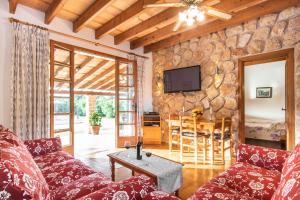 a living room with a couch and a tv on a stone wall at Finca Pollentia in Alcudia