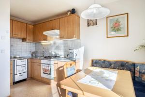 a small kitchen with a wooden table and a dining room at Stücklhof Wohnung Rose in San Genesio Atesino +28 photos