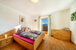 a bedroom with a wooden bed and a window at Stücklhof Wohnung Rose in San Genesio Atesino