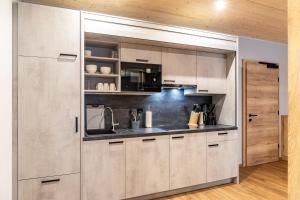 a kitchen with white cabinets and a sink at Ferienwohnung Hirsch-Loge in Pflach