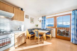 a kitchen and dining room with a table with a view at Stücklhof Wohnung Rose in San Genesio Atesino