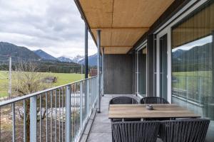 a porch with a wooden table and chairs on a balcony at Ferienwohnung Hirsch-Loge in Pflach