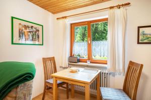 a dining room with a table and chairs and a window at Marie in Weiler-Simmerberg