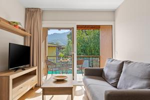 a living room with a couch and a television at 4 Terraza - Antilles sin jardin in Llanes