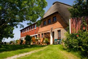 a large brick building with a thatched roof at Ferienwohnungen Appelhof in Pellworm +11 photos