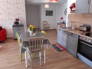 a kitchen with a table with chairs and a dining room at La Grange Aux Oiseaux in Beaulieu +19 photos