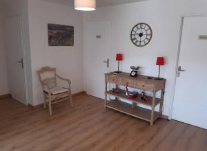 a room with a desk and a chair and a clock at La Grange Aux Oiseaux in Beaulieu
