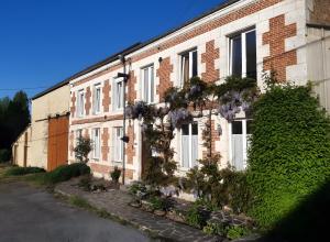 a brick building with flowers on the side of it at La Grange Aux Oiseaux in Beaulieu