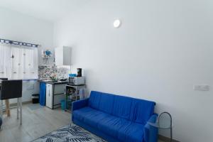 a blue couch in a living room with a kitchen at Villa Monica in Agüimes