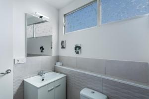 a white bathroom with a toilet and a sink at Villa Monica in Agüimes