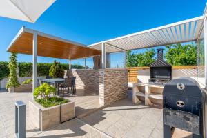 a patio with a grill and a table and a fireplace at Macisvenda relax in Macisbenda